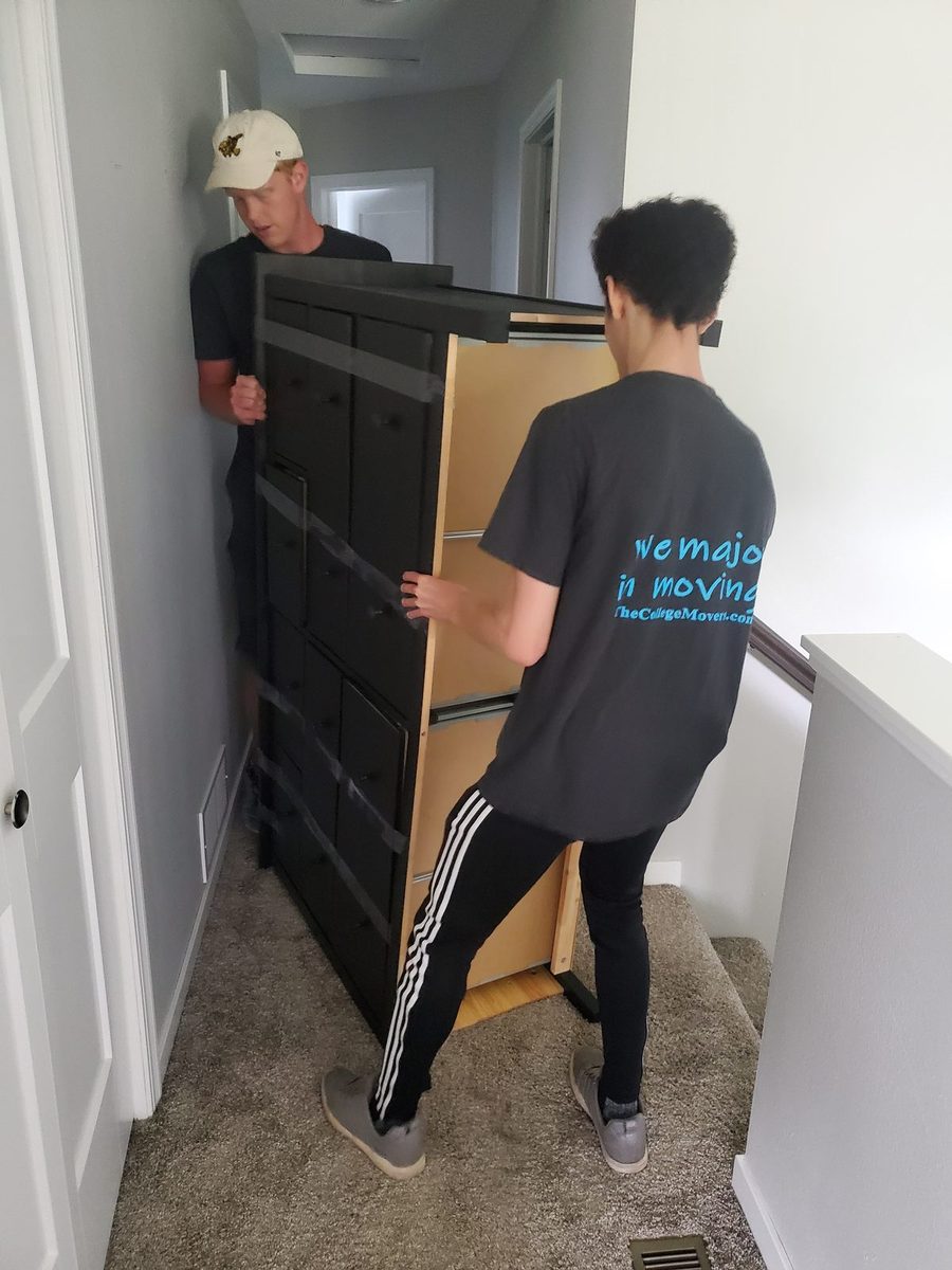 Student movers carrying furniture upstairs